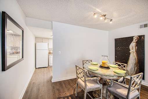 A dining room with a glass table and chairs.