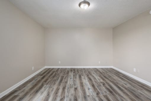 an empty room with vinyl flooring and white walls