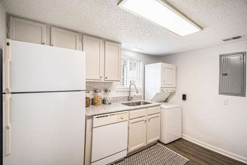 A kitchen with white appliances and cabinets.