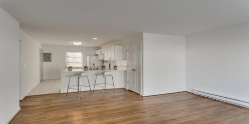 an empty living room and kitchen with a white