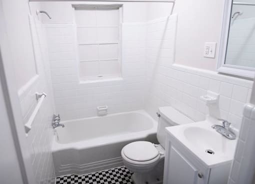 A white bathroom with a black and white checkered floor.