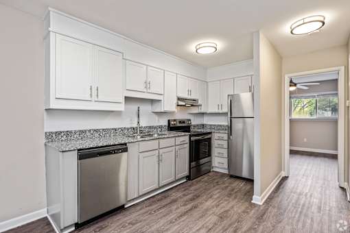 A kitchen with white cabinets and stainless steel appliances.