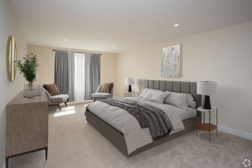 a bedroom with a bed and two chairs in a 555 waverly unit