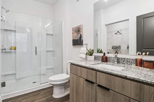 A modern bathroom with a white toilet and a marble countertop.at The Liliana Apartment Homes, Pooler, GA 31322