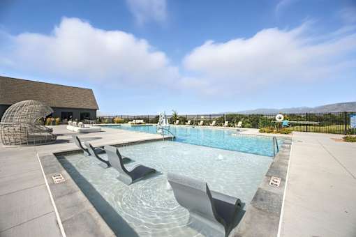 A large outdoor swimming pool with a sun lounger at The Garrison Luxury Apartment Homes, Fountain, CO 80817