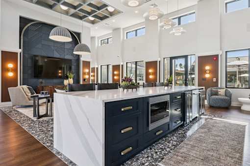 A modern kitchen with a large island and dark cabinets.at The Liliana Apartment Homes, Pooler