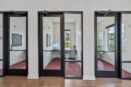 Three black doors open to a hallway with a red floor at The Hadley - North Port, FL Apartments, North Port, Florida