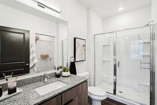A modern bathroom with a walk-in shower and a toilet. at The Pullman Luxury Apartments, Atlanta, Georgia