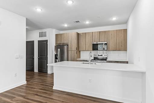 Modern kitchen with wood cabinetry and white island at Velara Luxury Apartments, Ponte Vedra Beach