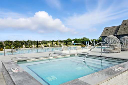 A large outdoor swimming pool with a slide at The Garrison Luxury Apartment Homes, Fountain, CO 80817