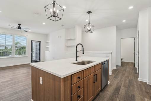 A kitchen with a white countertop and wooden cabinets.