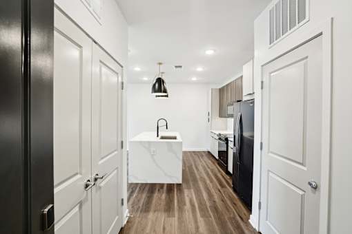 A modern kitchen with white cabinets and a black refrigerator. at The Pullman Luxury Apartments, Atlanta