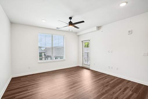 A room with a ceiling fan and wooden flooring. at The Pullman Luxury Apartments, Atlanta