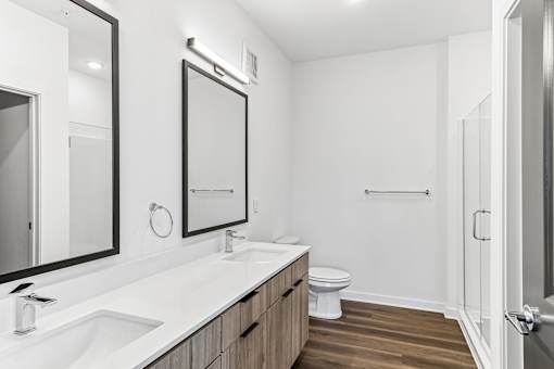 Modern bathroom with double vanity and wood flooring at Velara Luxury Apartments, Ponte Vedra Beach, FL