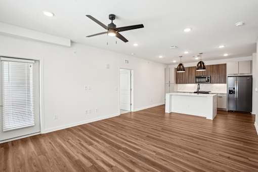 A room with a ceiling fan and wooden flooring. at The Pullman Luxury Apartments, Atlanta