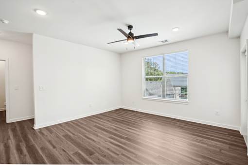 A room with a ceiling fan and a window with blinds. at The Pullman Luxury Apartments, Atlanta