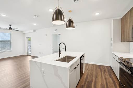 A modern kitchen with a white island and wooden floors. at The Pullman Luxury Apartments, Atlanta, Georgia