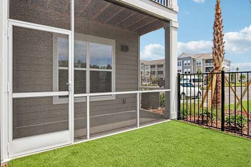 Screened patio with artificial turf and metal railing at Velara Luxury Apartments, Ponte Vedra Beach, Florida