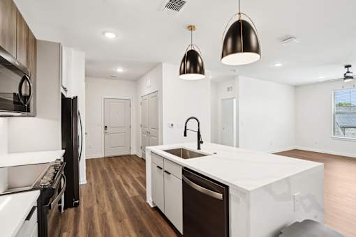 A modern kitchen with a white countertop and dark wood flooring. at The Pullman Luxury Apartments, Atlanta, Georgia