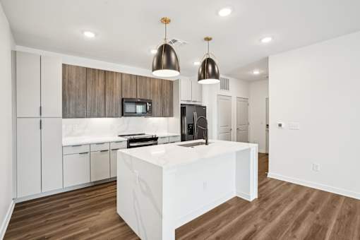A modern kitchen with white cabinets and a wooden backsplash. at The Pullman Luxury Apartments, Atlanta, Georgia