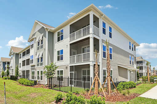 Three story apartment building with balconies and landscaping at Velara Luxury Apartments, Ponte Vedra Beach