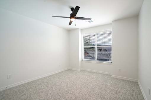 A room with a ceiling fan and a window with blinds. at The Pullman Luxury Apartments, Atlanta, GA