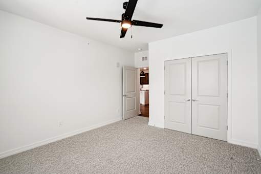 A room with a ceiling fan and carpeted floor. at The Pullman Luxury Apartments, Atlanta