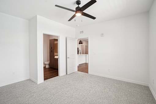 A room with a ceiling fan and carpeted floor. at The Pullman Luxury Apartments, Georgia, 30349