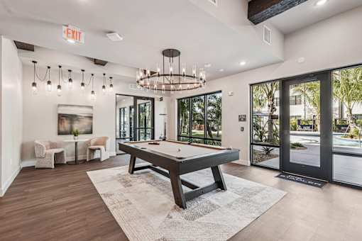 A room with a pool table and a chandelier at The Stadler Luxury Apartments, Bradenton, Florida