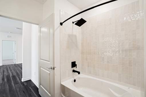 A modern bathroom with a white tub and a black track light. at The Pullman Luxury Apartments, Atlanta, GA, 30349
