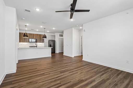 Open living area with modern kitchen and wood flooring at Velara Luxury Apartments, Florida