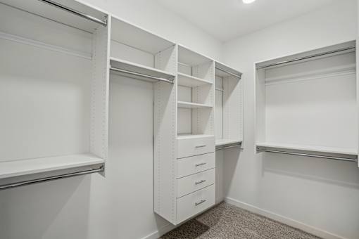 A white walk-in closet with shelves and drawers. at The Pullman Luxury Apartments, Georgia, 30349