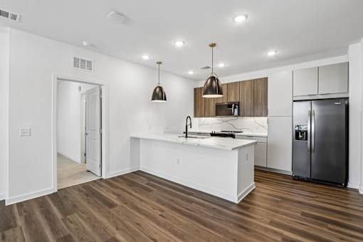 Contemporary kitchen with white marble countertops and pendant lighting at Velara Luxury Apartments, Ponte Vedra Beach, FL