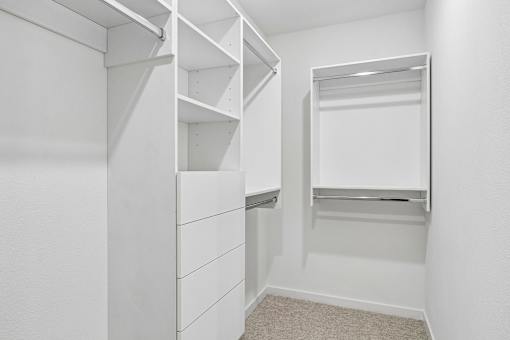 Walk-in closet with white shelving and hanging rods at Velara Luxury Apartments, Ponte Vedra Beach, Florida