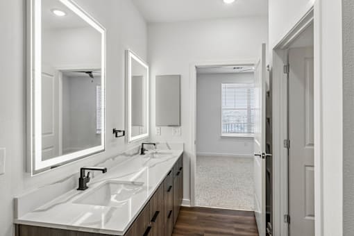 Dual sink bathroom vanity with backlit mirrors at Velara Luxury Apartments, Ponte Vedra Beach