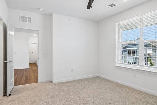 Empty bedroom with carpet and large window at Velara Luxury Apartments, Florida