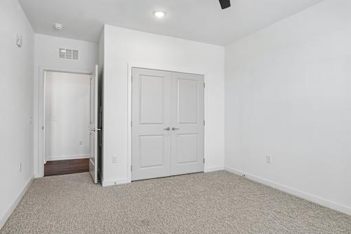 Empty bedroom with carpet and double closet doors at Velara Luxury Apartments, Florida, 32081