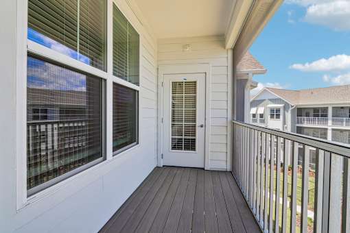 Private balcony with dark wood decking and metal railing at Velara Luxury Apartments, Ponte Vedra Beach, Florida