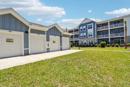 Garages with apartment buildings and green lawn at Velara Luxury Apartments, Florida, 32081