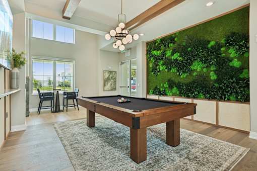 A pool table in a room with a green wall.