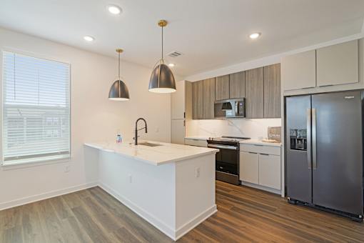 Modern kitchen with white island and wood tone cabinets at Velara Luxury Apartments, Ponte Vedra Beach, Florida