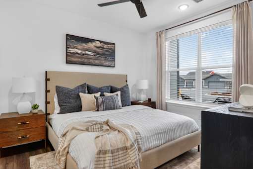 A bedroom with a large bed and a painting on the wall.at The Logan Luxury Apartments, Nampa, ID, 83651