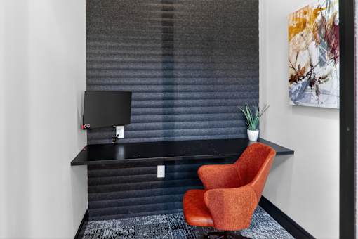 A red chair sits in front of a black desk with a computer on it.at The Logan Luxury Apartments, Nampa, ID, 83651