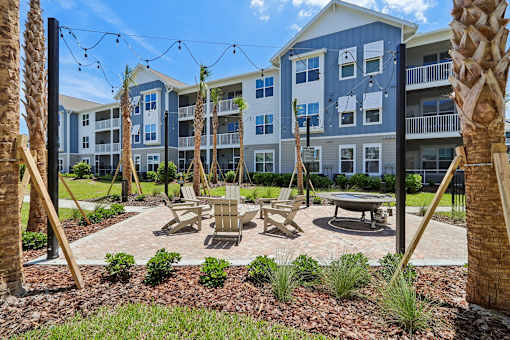 Courtyard patio with swings fire table and palm trees at Velara Luxury Apartments, Ponte Vedra Beach, FL 32081
