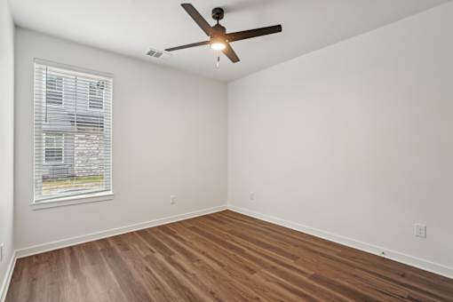 A room with a ceiling fan and a window with blinds. at The Pullman Luxury Apartments, Atlanta, 30349