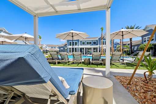 Poolside cabana with lounger and umbrella seating at Velara Luxury Apartments, Florida