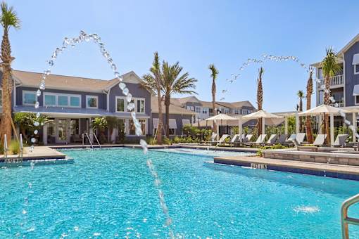 Swimming pool with water features and palm trees at Velara Luxury Apartments, Ponte Vedra Beach, Florida