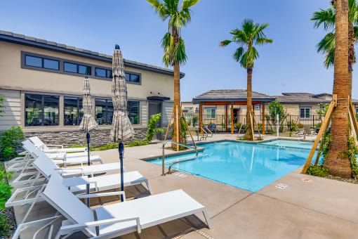 our apartments have a swimming pool with chairs and palm trees at Grandstone at Sunrise, Peoria, 85383