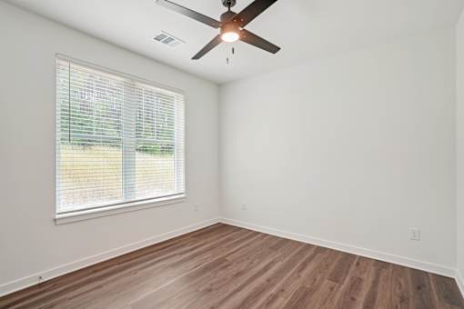 A room with a ceiling fan and a window with blinds. at The Pullman Luxury Apartments, Atlanta, GA