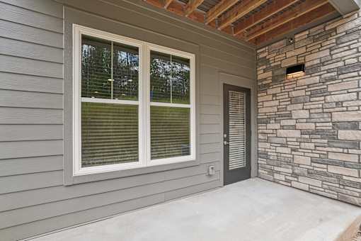 A house with a grey siding and a stone wall. at The Pullman Luxury Apartments, Atlanta